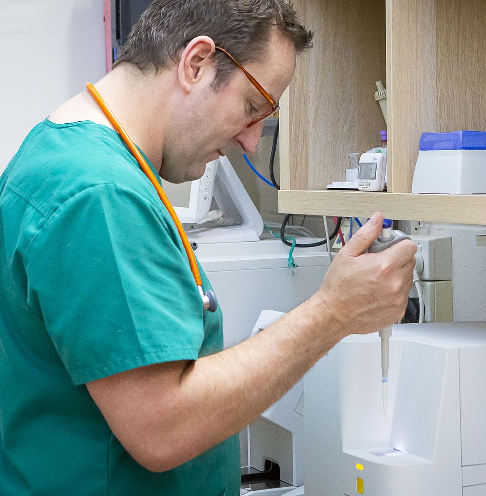 A male healthcare professional using a medical device in a clinic.